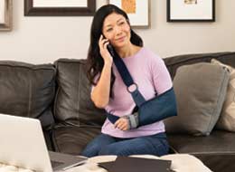 woman with arm cast working on laptop