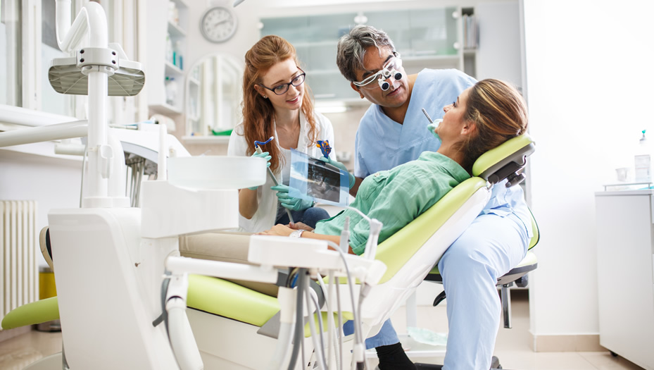 dentist and dental assistant with patient in chair