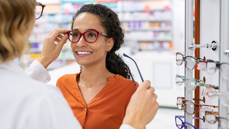 optometrist trying glasses on patient