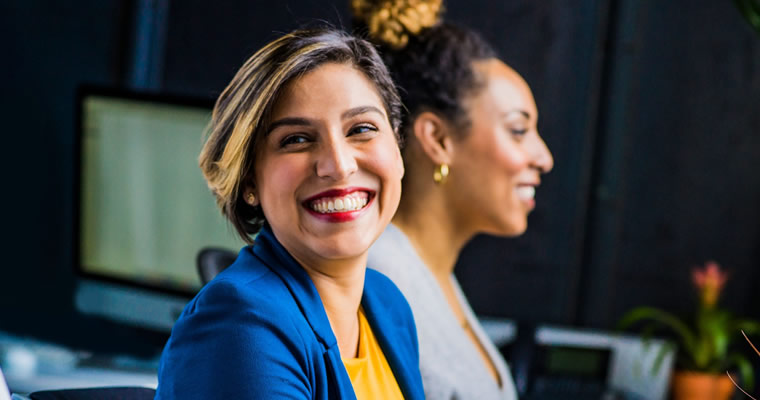 Woman in blue jacket smiling.