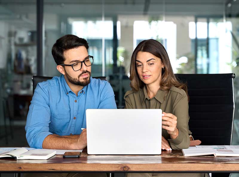 two coworkers looking at laptop