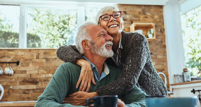older man and woman holding each other and smiling