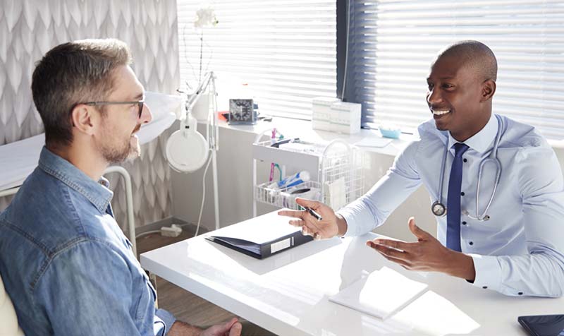 man talking with a doctor at a desk