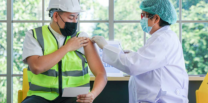 construction working getting a shot in his arm