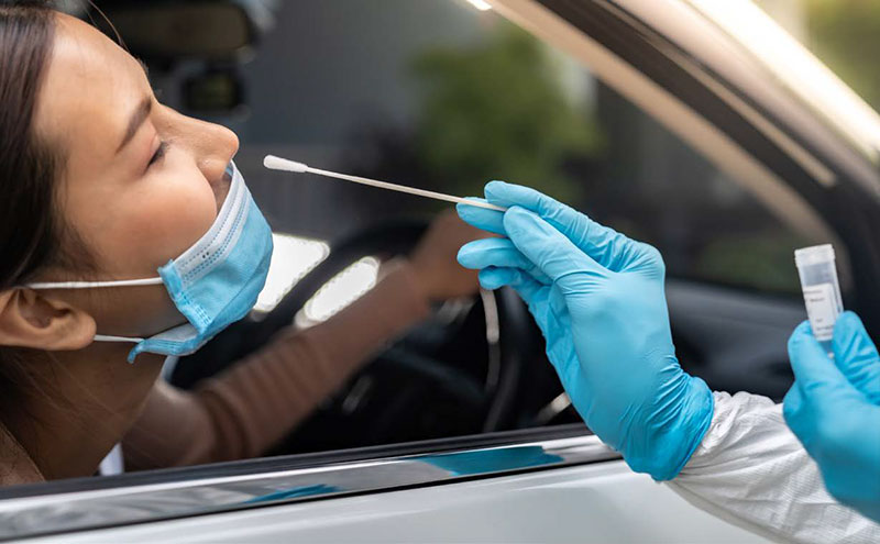 person getting a nose swab at a drive thru testing center