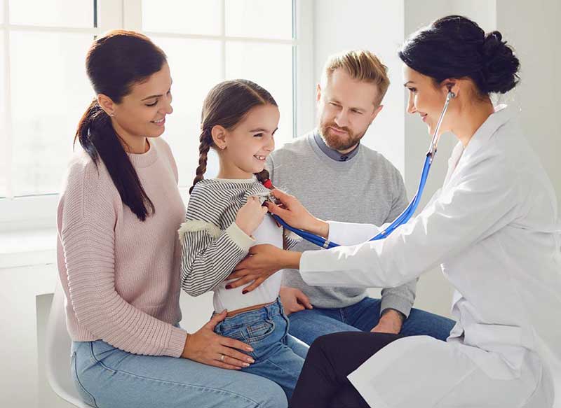 doctor listening to little girl's heart