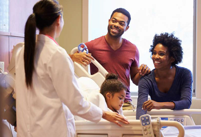 family around little girl in a hospital bed