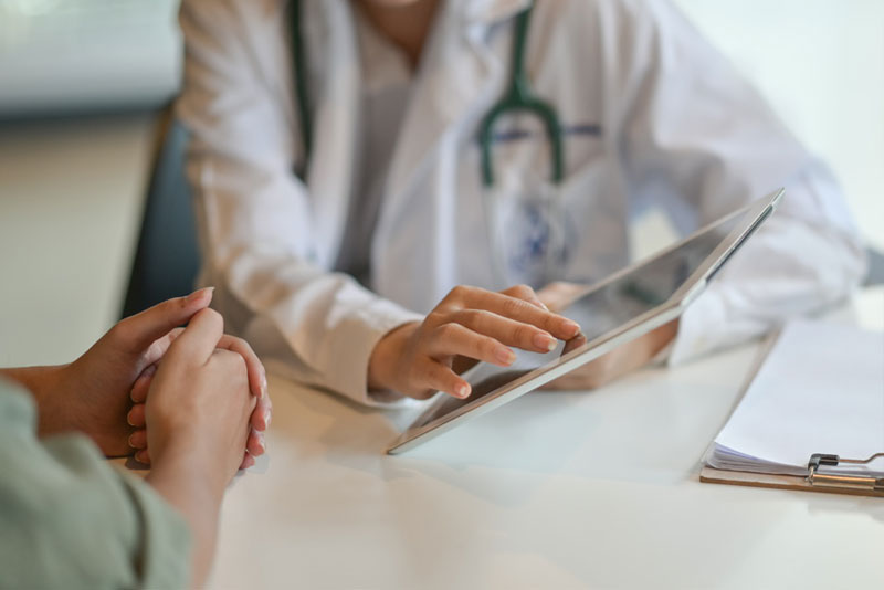 medical personal with tablet talking with patient