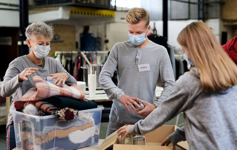 three volunteers sorting donations