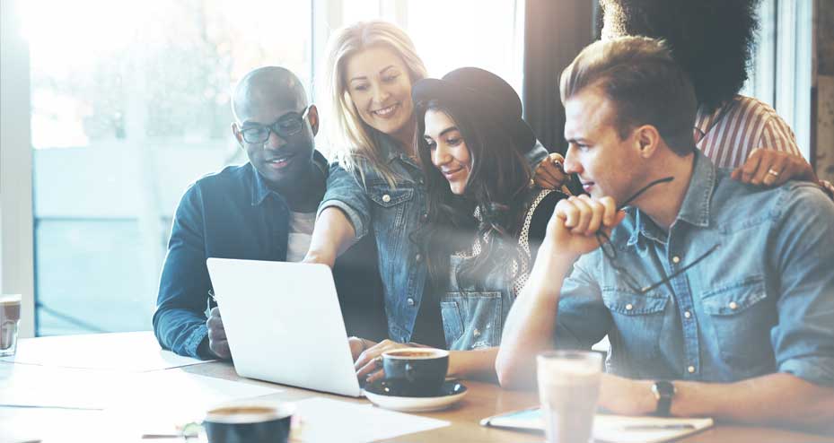 group of coworkers looking at a laptop