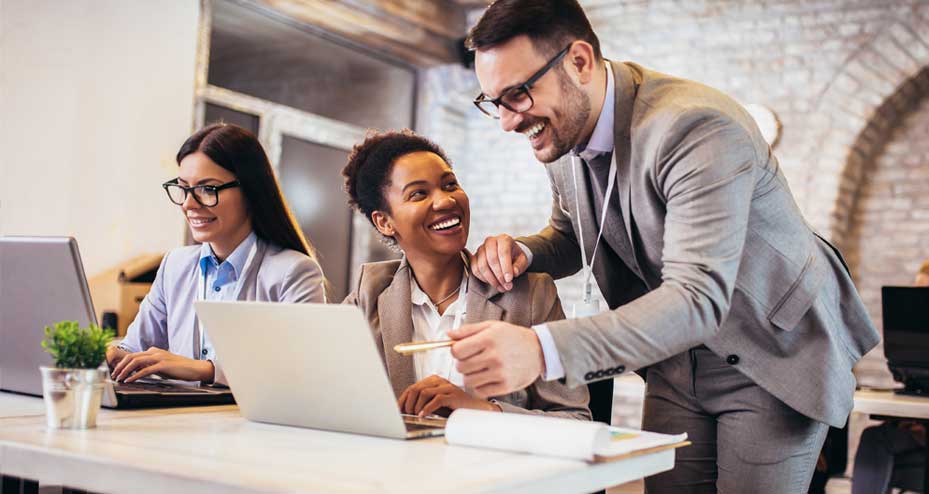 happy coworkers working at laptop together