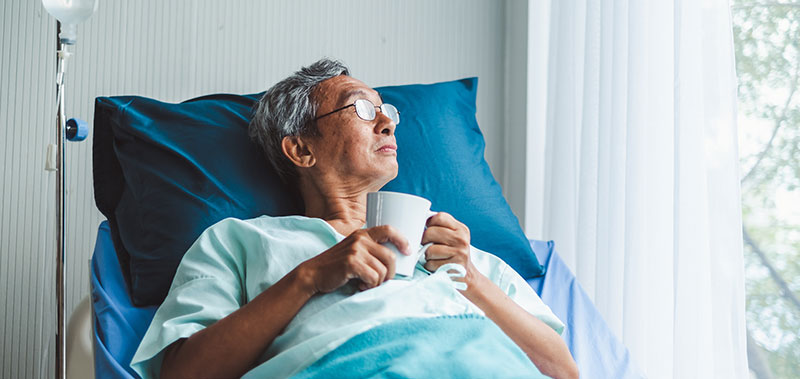 patient looking out window from hospital bed