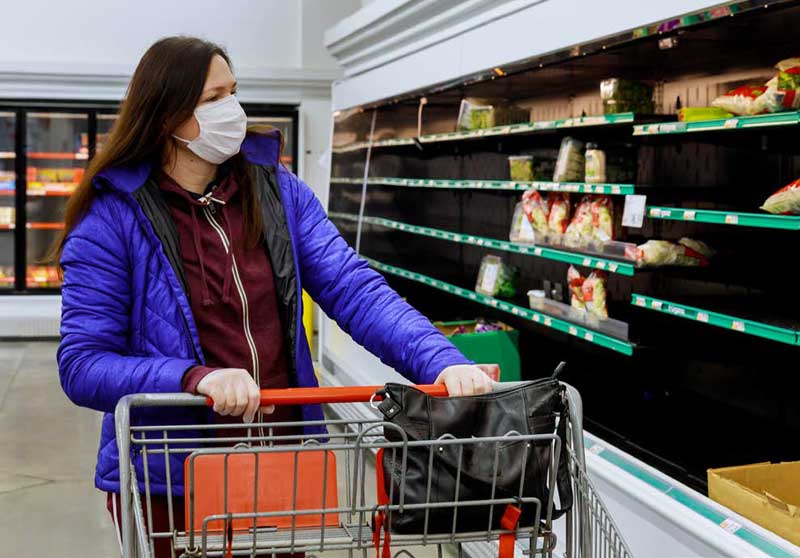 woman shopping in grocery store with lots of empty shelves