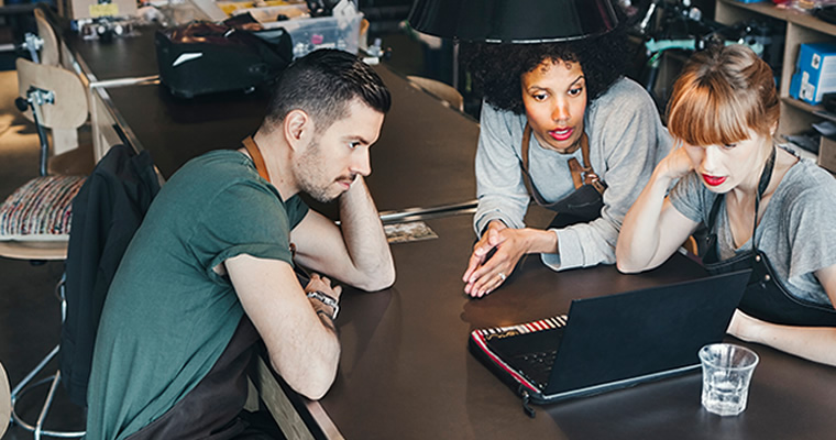 employees looking at a computer having a discussion