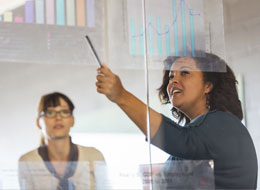 Woman pointing at charts on wall