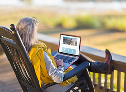 woman sitting in chair looking at a laptop computer