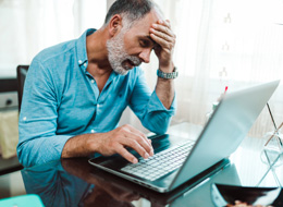 stressed man working on laptop