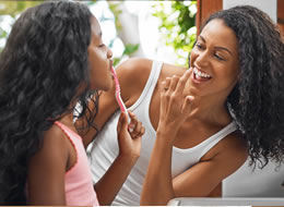 mother and daughter brushing their teeth