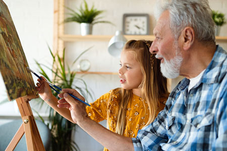 grandfather and granddaughter painting together