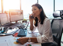woman sitting at work desk talking on the phone