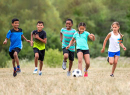 children running with a soccer ball