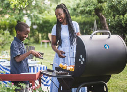 mother and son cooking out on a grill