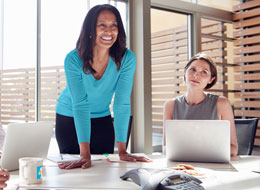 woman leaning over conference table