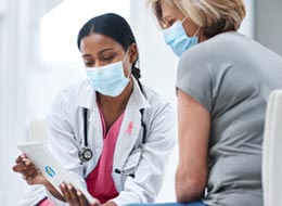 woman and doctor looking at tablet