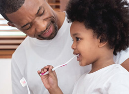 father and child brushing teeth