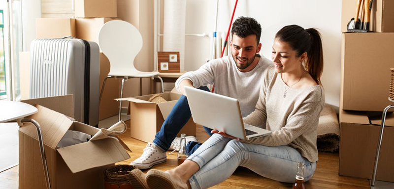 couple sitting on a couch using a laptop computer