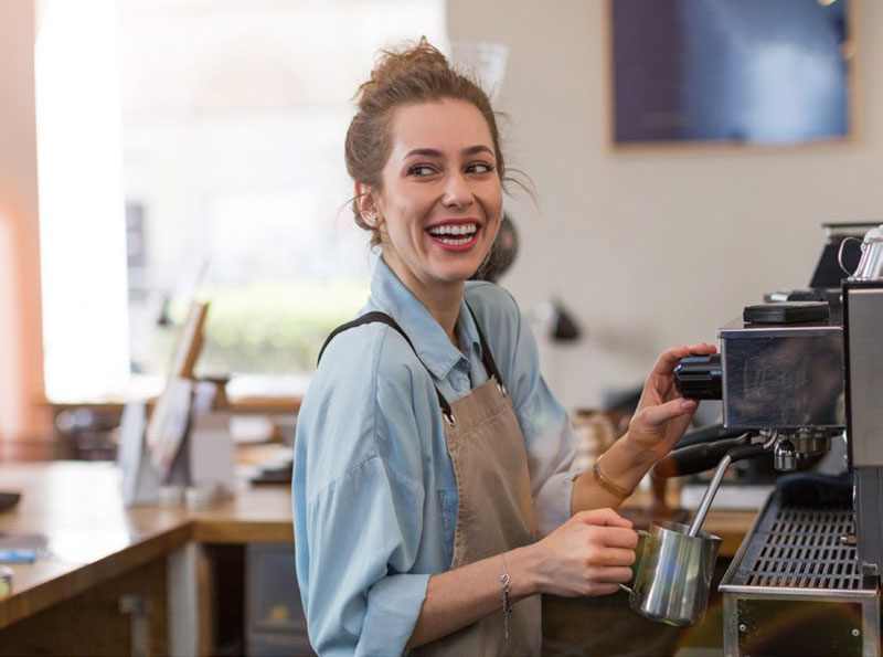 barista smiles while making coffee