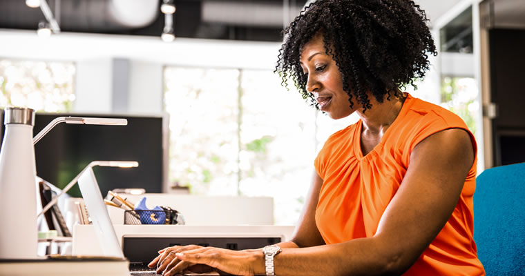 woman at a desk typing on a computer