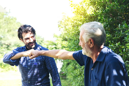 father and son fist bumping