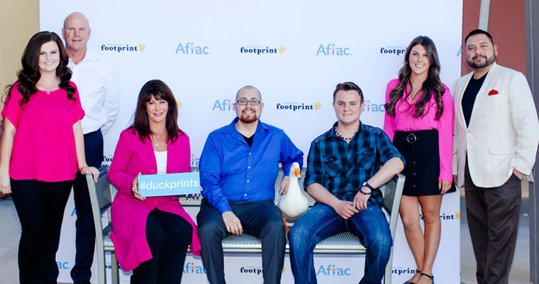 people pose with Aflac duck and #duckprints hashtag signs