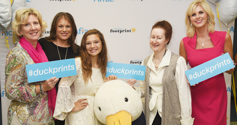 people pose with Aflac duck and #duckprints hashtag signs