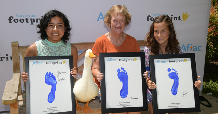 people pose with Aflac duck and #duckprints hashtag signs