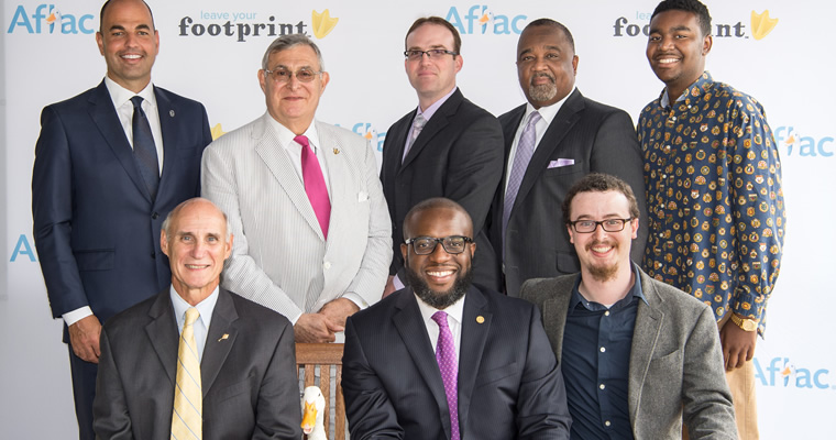 people pose with Aflac duck and #duckprints hashtag signs