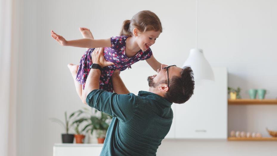 father lifting his daughter in the air