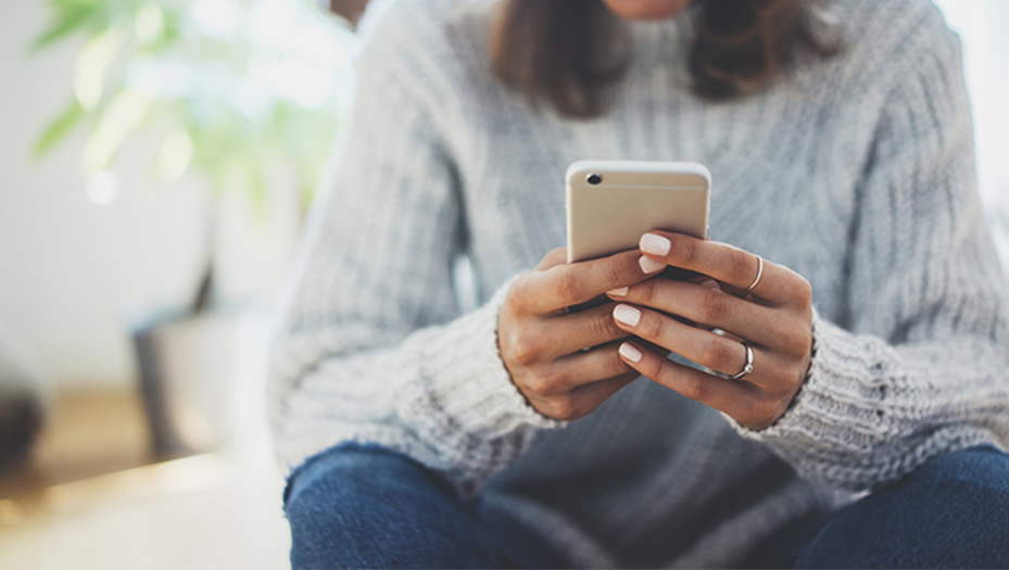 Woman checking the SmartClaim Aflac app on her mobile device.