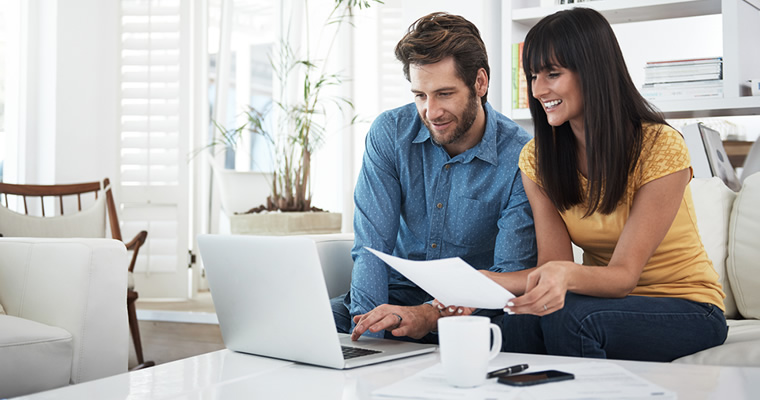 couple looking at documents and computer