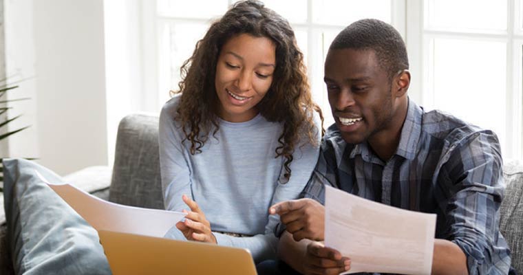 couple looking at papers and a laptop