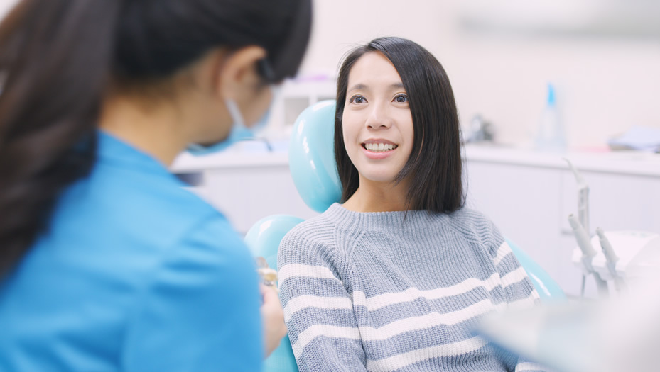 dentist talking to patient in chair