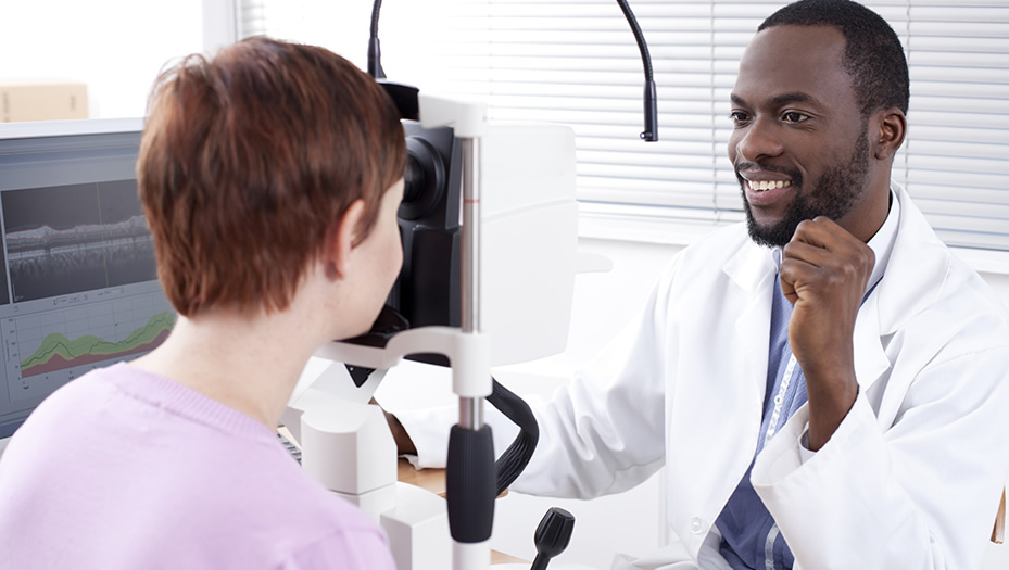 optometrist conducting an eye exam with patient