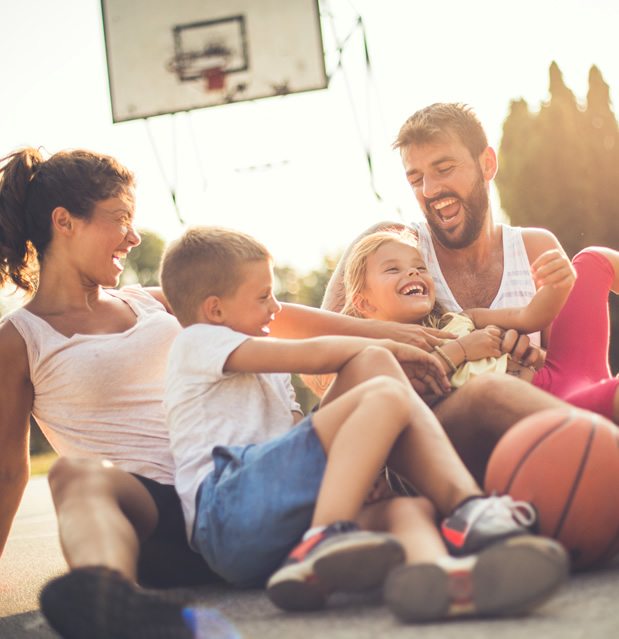 family laughing on a basketball court