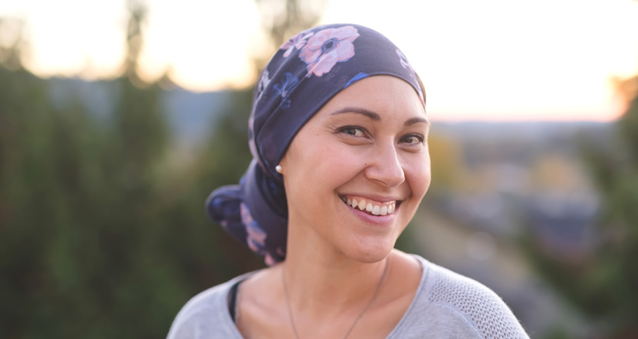 cancer patient smiling, wearing a head covering