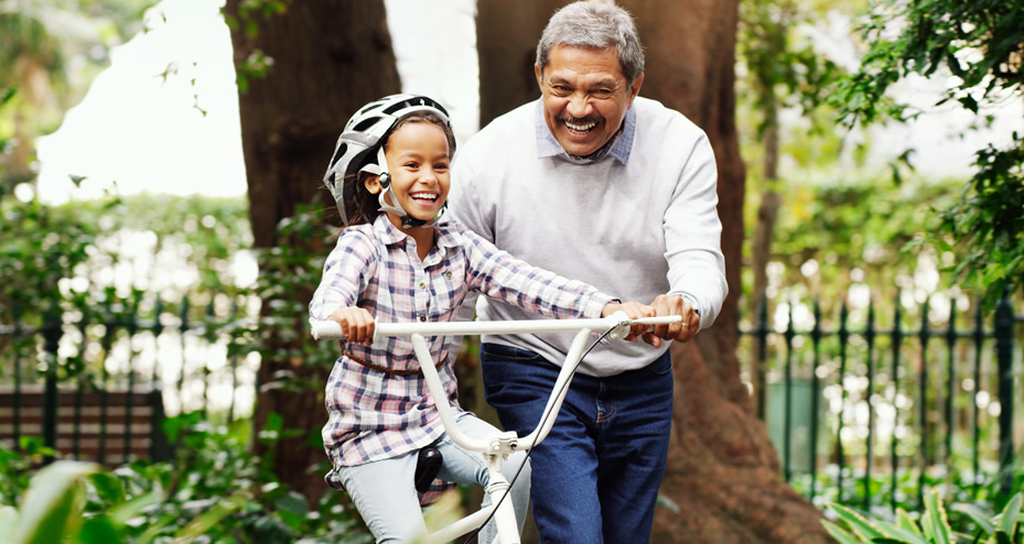 grandfather showing granddaughter how to ride a bike