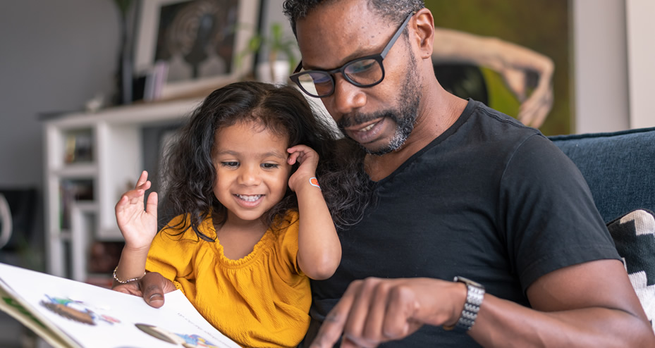 father and daughter reading a book