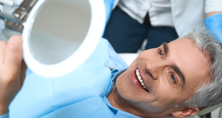 patient in dental chair looking into a mirror