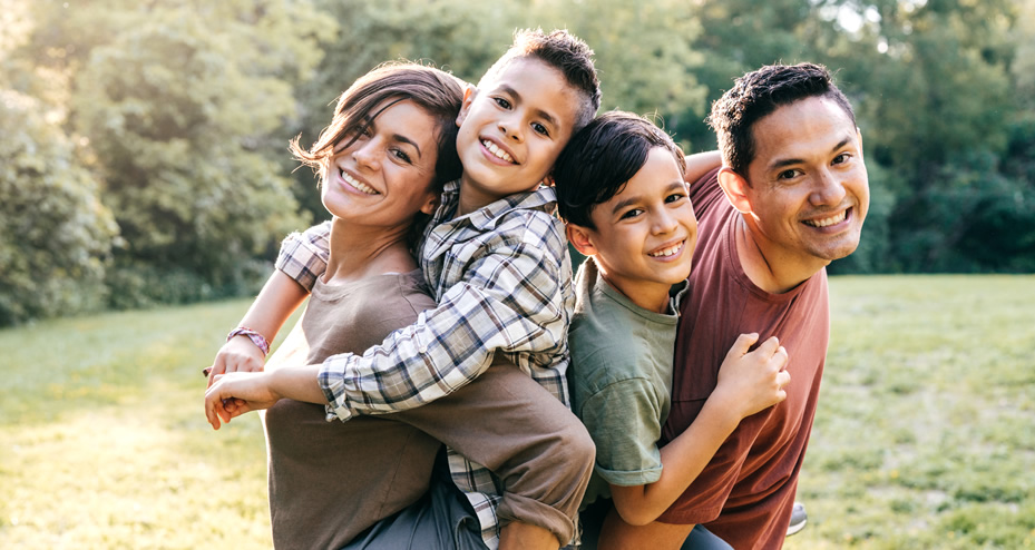 couple holding their children in a park