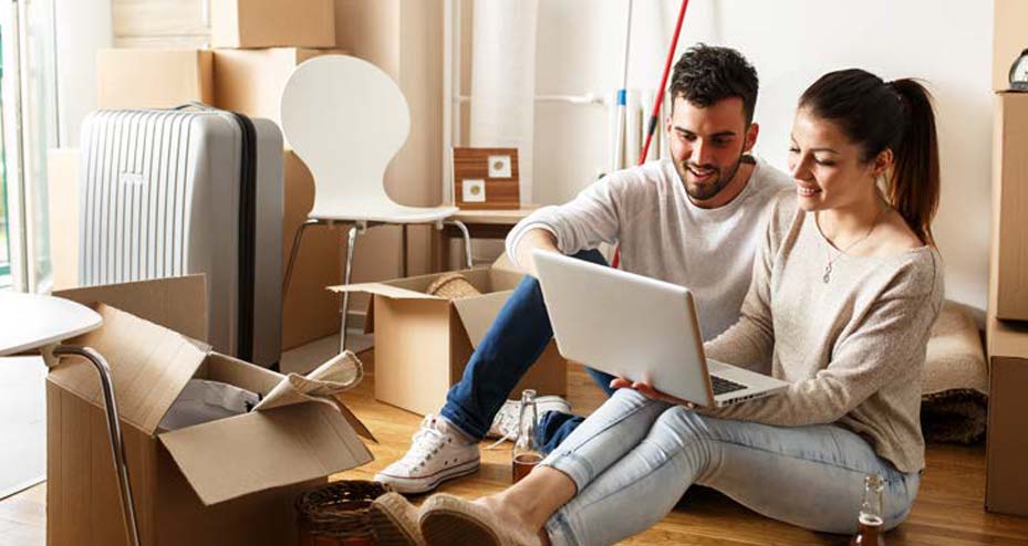 couple sitting on floor looking at laptop